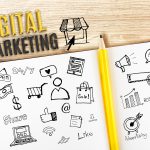 Notebook on wooden desk with Digital Marketing word